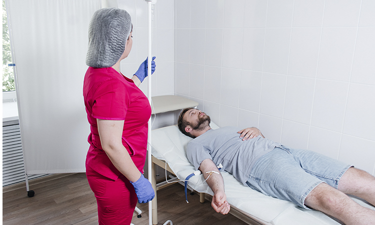 Медсестра делает капельницу пациенту в стационаре